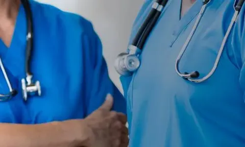 BSN准备护士在蓝色手术服讨论病人护理
